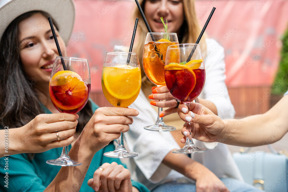 Group of happy friends toasting, saying cheers with tropical cocktails. Party time and youth concept Group of happy friends toasting, saying cheers with tropical cocktails. Party time and youth concept