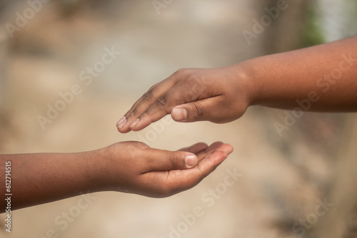 Two boys are holding one another's hand and the background is blurred behind them © Rokonuzzamnan