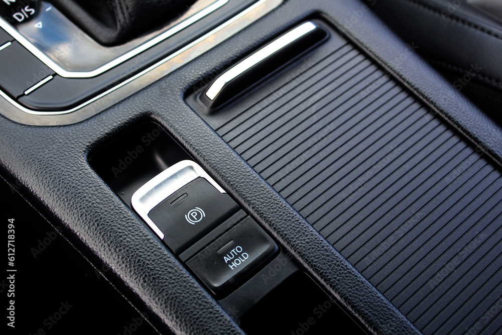 Car storage box. Electronic handbrake in car. Handbrake button. Leather car interior. Lux car interior with carbon fiber trims.