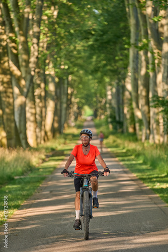 attractive senior woman cycling with her electric mountain bike in the city park of Stuttgart, Baden-Wuerttemberg, Germany