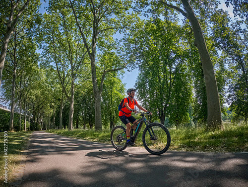 attractive senior woman cycling with her electric mountain bike in the city park of Stuttgart, Baden-Wuerttemberg, Germany