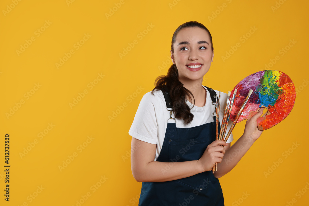 Fototapeta premium Woman with painting tools on yellow background, space for text. Young artist