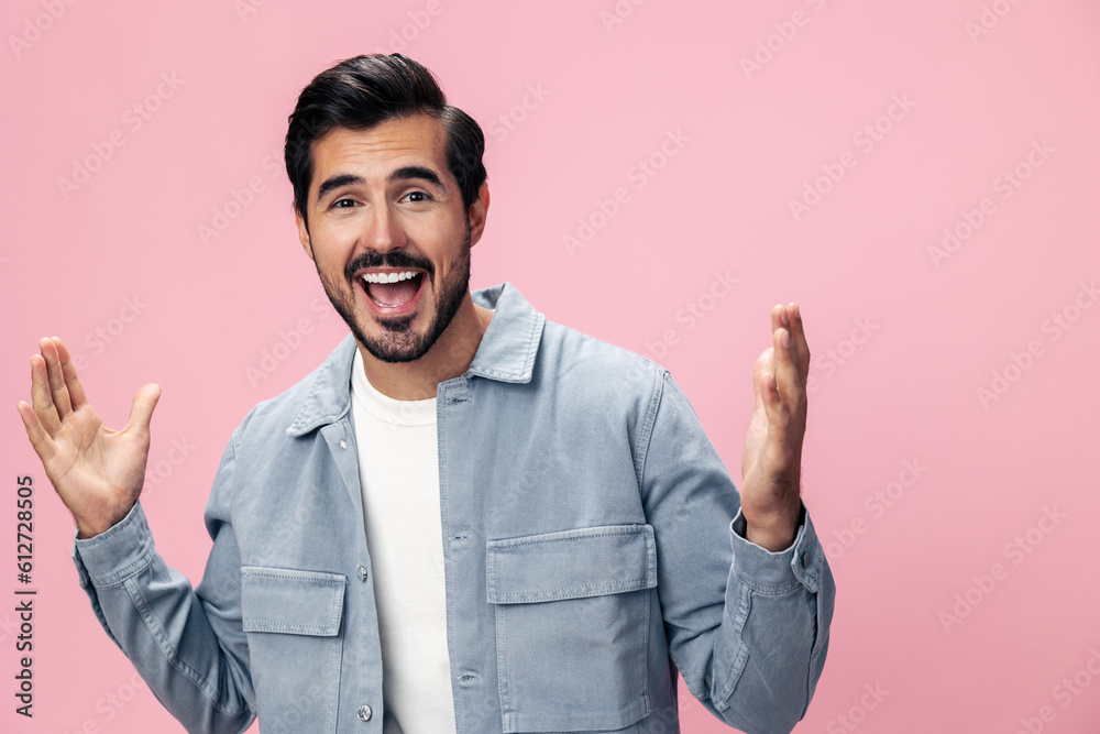 Portrait of a stylish brunette man with a beard raised his hands up with surprise open pink background in a white T-shirt and jeans smile and joyful emotion on his face, copy space Portrait of a stylish brunette man with a beard raised his hands up with surprise open pink background in a white T-shirt and jeans smile and joyful emotion on his face, copy space