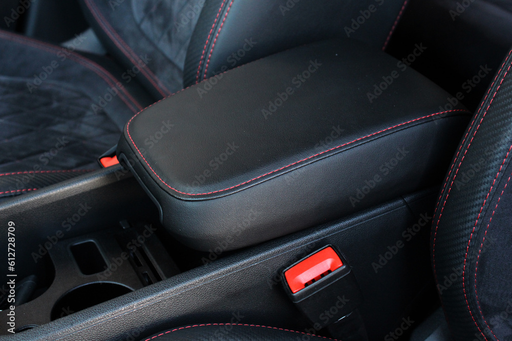 Leather sport car interior. Armrest with Seat Adjustment Buttons. Sport Car armrest with storage box. Sport Car interior with carbon fiber trims, leather seats and black stitches. 