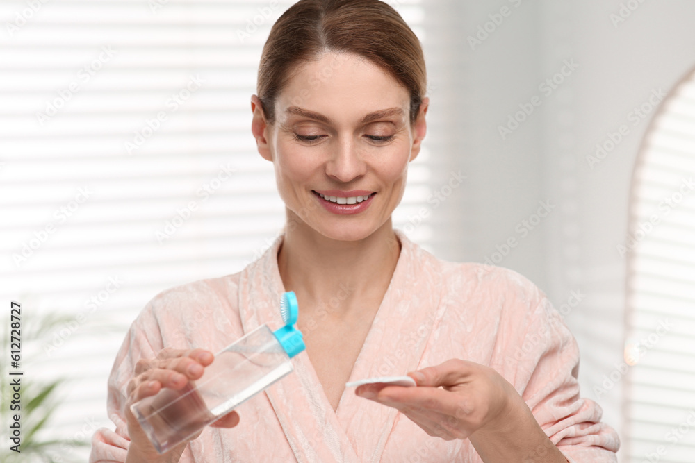 Beautiful woman with makeup remover and cotton pad indoors Beautiful woman with makeup remover and cotton pad indoors