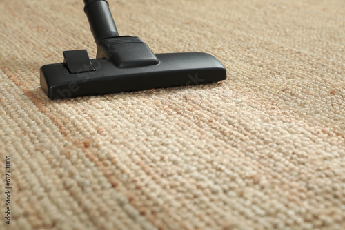 Hoovering carpet with vacuum cleaner, closeup. Clean trace on dirty surface