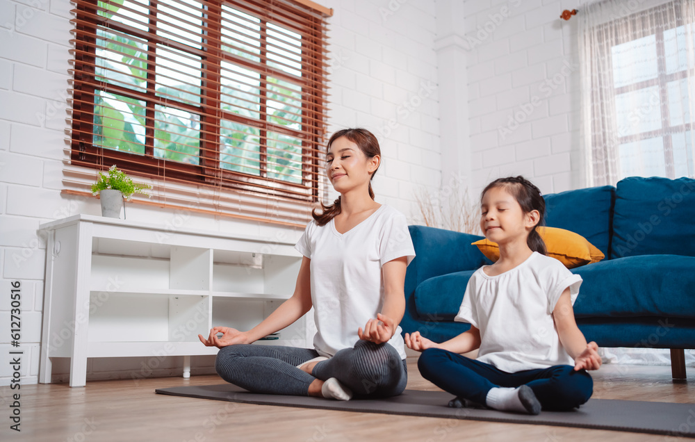 Fototapeta premium Mother and daughter exercising together happily at home. for flexibility build muscle strength, Sport workout training family together concept.