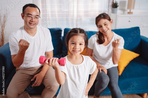 Family consisting of parents and daughters happily exercising together at home. For flexibility, build muscle strength, Sport Workout Training family together.