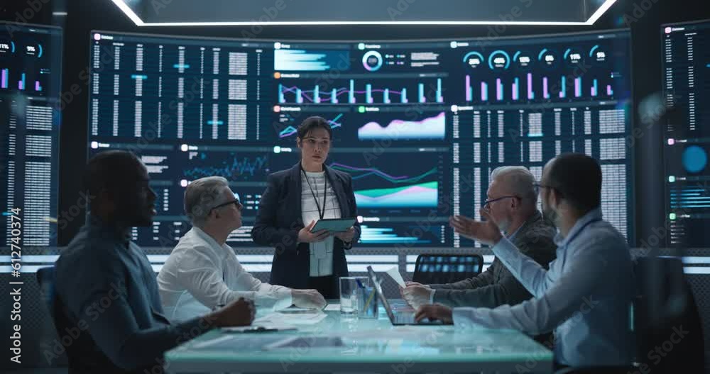 Management Meeting in a Big Data Monitoring Company. Diverse Team of Data Scientists Discussing Graphs and Reports on a Big Digital Screen in the Office. Female Team Leader is Making a Presentation