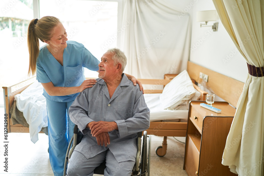 Nurse with elderly man sitting in wheelchair at rehab center