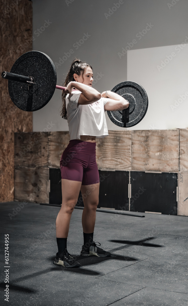 woman carrying a heavy barbell in the gymnasium