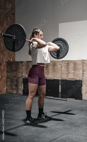 Obraz na płótnie woman carrying a heavy barbell in the gymnasium w salonie