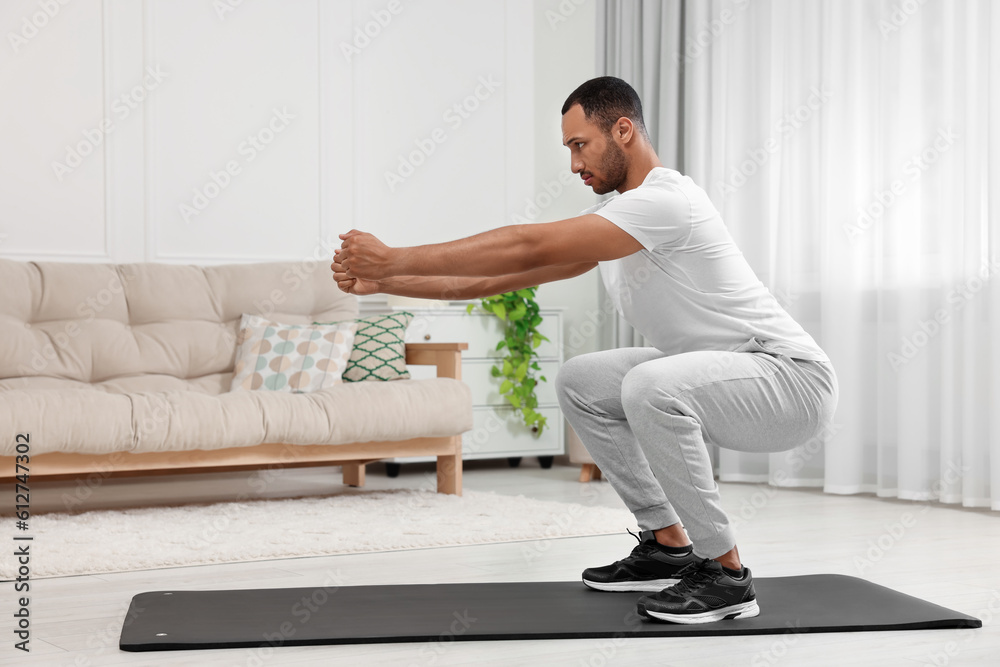 Man doing morning exercise on fitness mat at home Man doing morning exercise on fitness mat at home