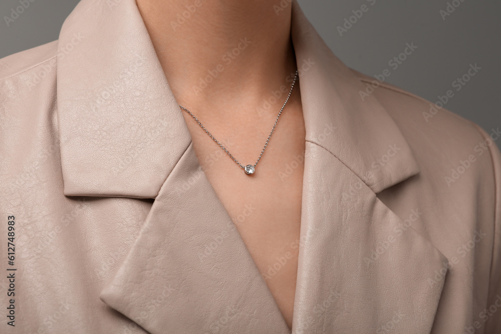 Woman with elegant necklace on dark grey background, closeup Woman with elegant necklace on dark grey background, closeup