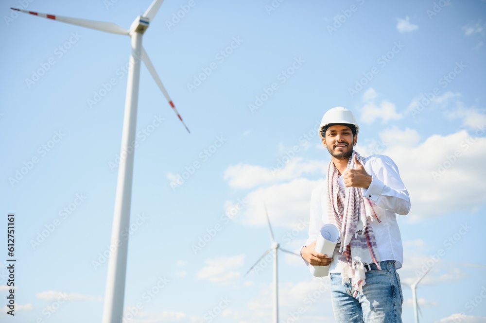 Indian Engineer in wheat field checking on turbine production Indian Engineer in wheat field checking on turbine production