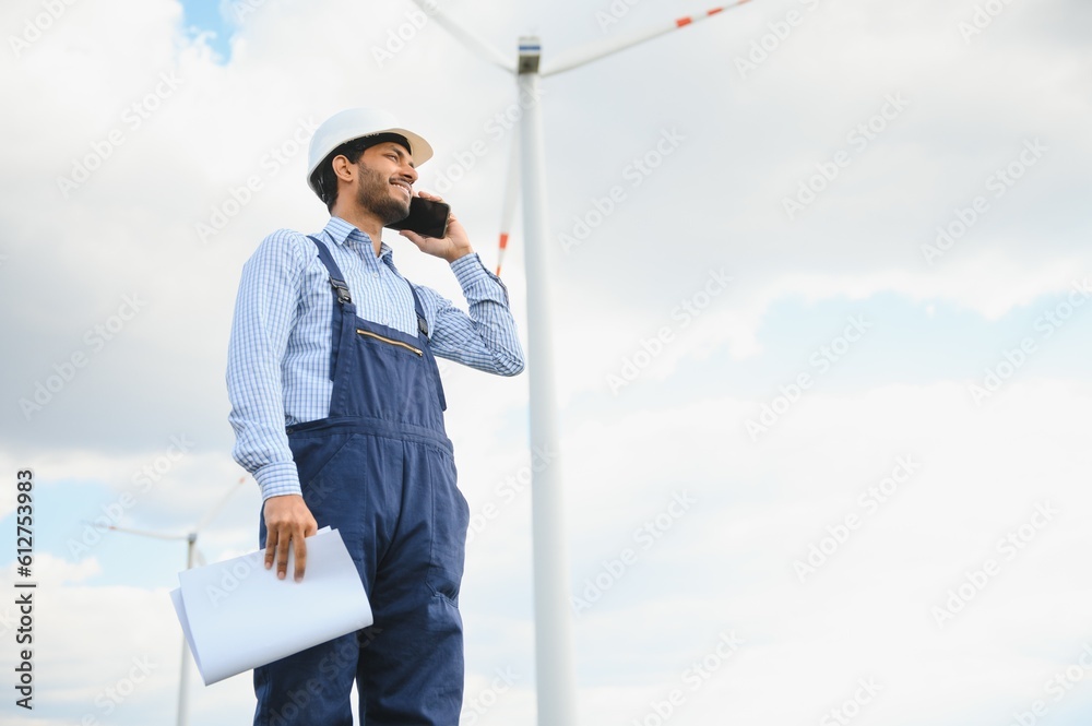 India engineer at windmill farm operation to generate electricity, Asian man working at wind turbine farm, Clean and green energy. India engineer at windmill farm operation to generate electricity, Asian man working at wind turbine farm, Clean and green energy.