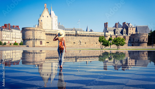 Woman walking in mirror water in Nantes- Loire-Atlantique,  Pays de la Loire in France- Castle of the Dukes of Brittany