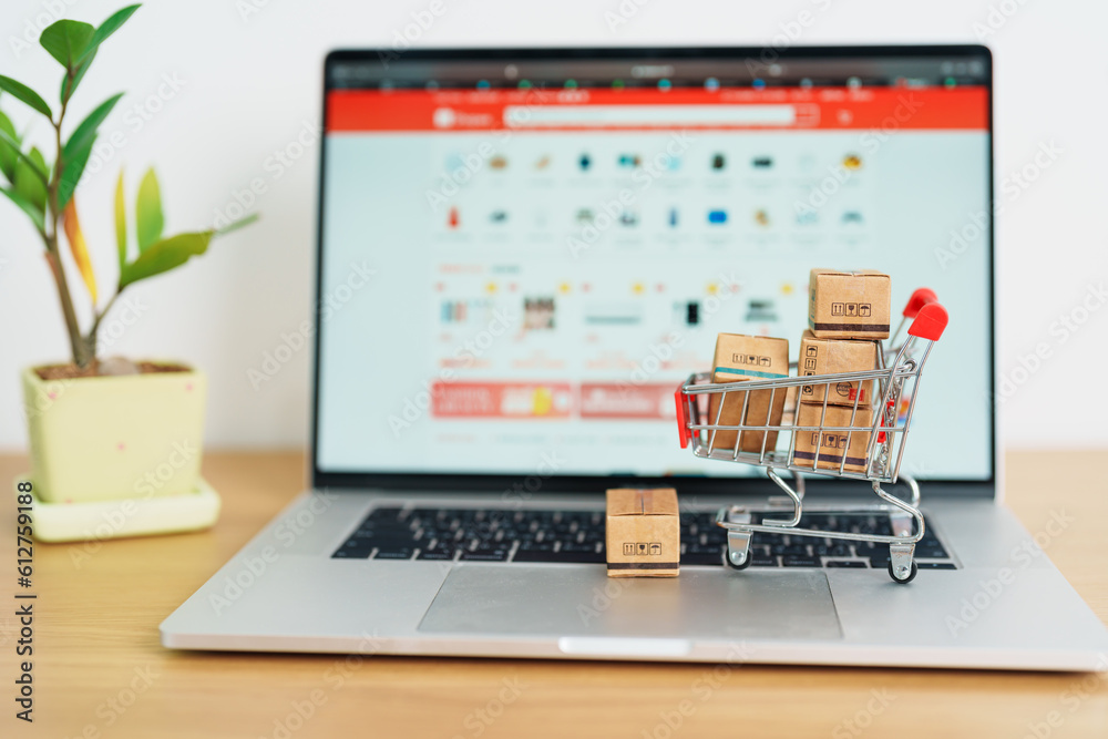 Boxes with shopping cart on a laptop computer. online shopping, Marketplace platform website, technology, ecommerce, shipping delivery, logistics and online payment concepts