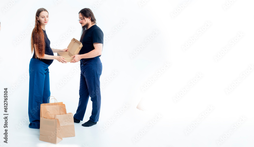 Portrait happy young pregnant woman and her husband with shopping bags and touching her big belly isolated on white background. Pregnancy shopping concept happy young family with shopping bags Portrait happy young pregnant woman and her husband with shopping bags and touching her big belly isolated on white background. Pregnancy shopping concept happy young family with shopping bags
