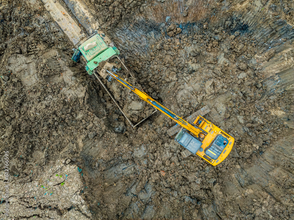 Aerial view of excavator equipment at the construction site. The excavator digs earthwork at the construction site.