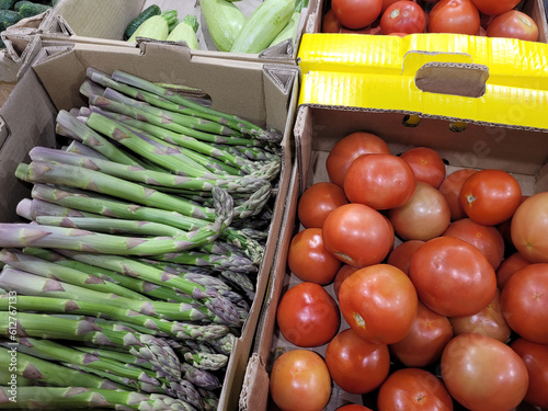 Fresh vegetables in the supermarket in boxes of asparagus and tomatoes