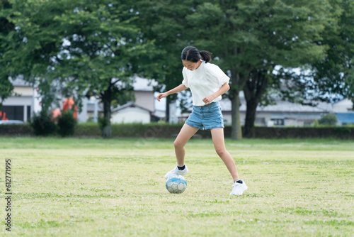 公園でサッカーをする小学生の女の子