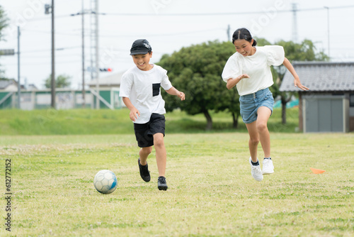 公園でサッカーをするアジア人の子供 © tatsushi