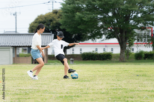 公園でサッカーをするアジア人の子供