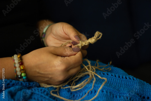 Hands of a woman and jute thread and fragment of a knitted pattern. natural eco knitting, craft and hobby, eco home decor.
