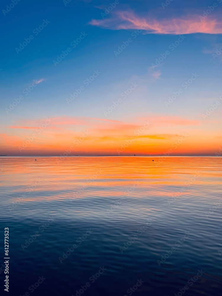Obraz premium calm orange sea twilights, sky reflection on the city surface, evening seascape background