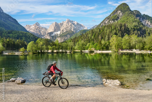 active senior woman on a mountain bike tour at Lake Jezero Jasna in the Triglav National Park near Kranska Gora, Julian Alps, Slovenia