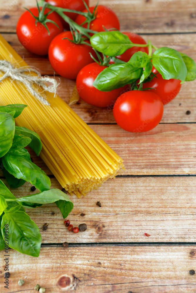 spaghetti and tomatoes basil on wooden table spaghetti and tomatoes basil on wooden table