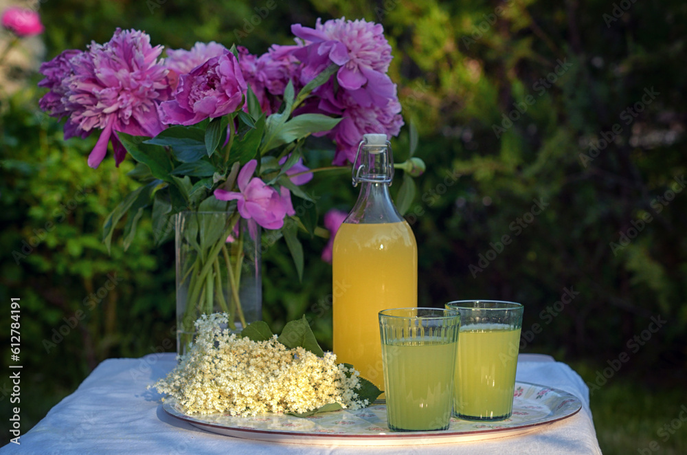 A Bottle and Glasses Of Homemade Lemonade Made From Elderberry Syrup