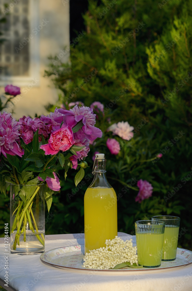 A Bottle and Glasses Of Homemade Lemonade Made From Elderberry Syrup