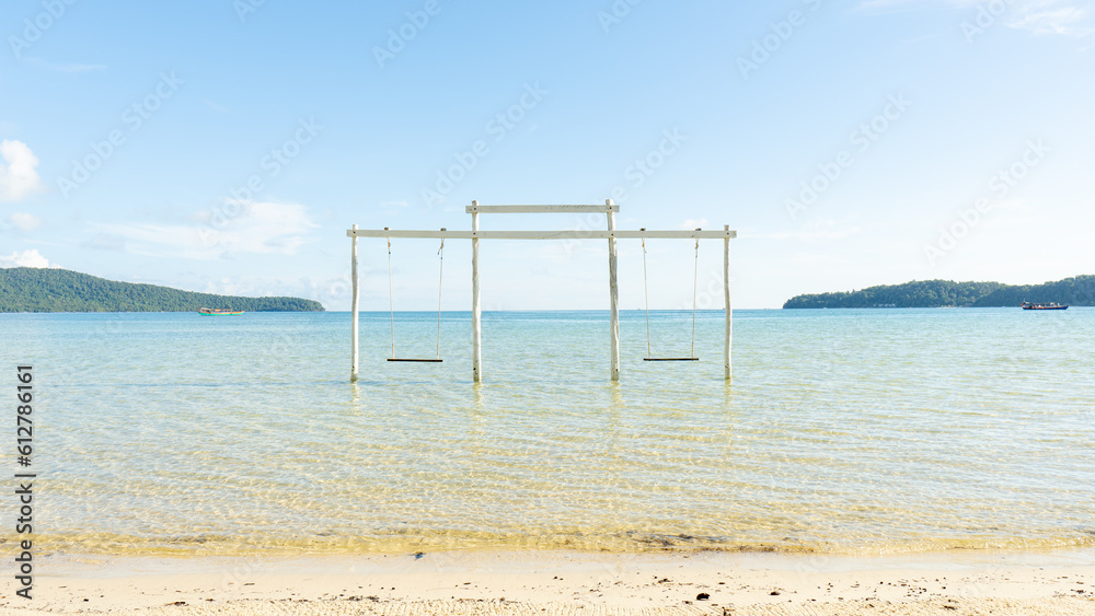 Swing in the beautiful ocean with clear water and mountain on the background in daytime. Beautiful island with clear water Swing in the beautiful ocean with clear water and mountain on the background in daytime. Beautiful island with clear water