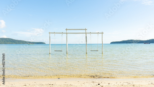 Swing in the beautiful ocean with clear water and mountain on the background in daytime. Beautiful island with clear water 