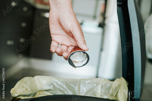 man throws a coffee capsule to the dustbin photo