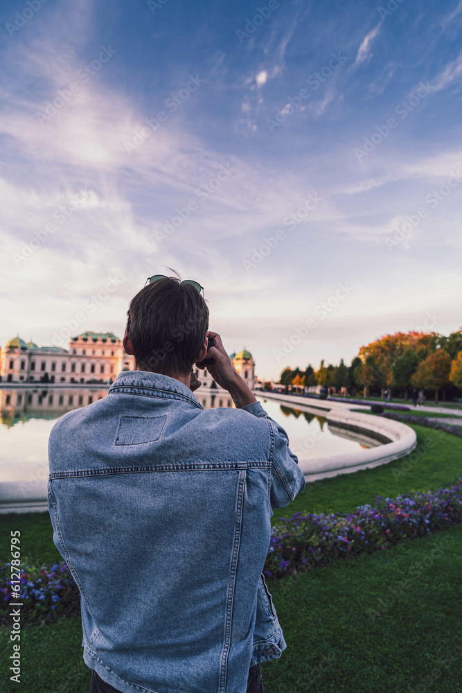 Man in front of Belvedere palace in Vienna at sunset 