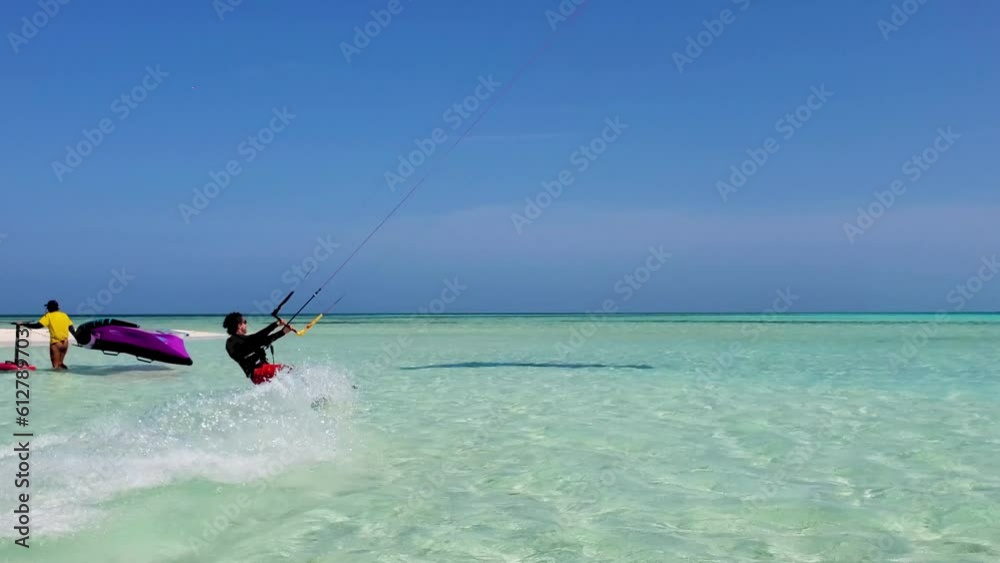 Man kitesurf on turquoise caribbean sea from left to right near beach camp sandbank Man kitesurf on turquoise caribbean sea from left to right near beach camp sandbank