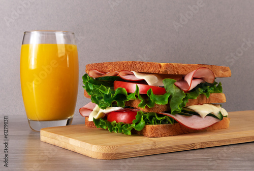 Sandwich with ham, cheese, lettuce, tomato and orange juice