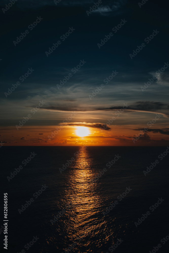 Fototapeta premium Bright orange sunset on the dark Indian Ocean on Bali island. Evening sunlight, fire sky, amazing view