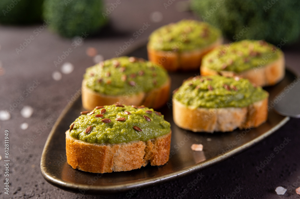 Mashed broccoli on slices of bread, sprinkled with flax seeds. Broccoli puree. Mashed broccoli on slices of bread, sprinkled with flax seeds. Broccoli puree.