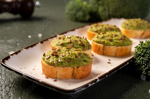 Mashed broccoli on slices of bread, sprinkled with flax seeds. Broccoli puree.