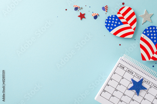 Fourth of July preparations: top view of symbolic embellishments, calendar marking special date, hearts with American flag, confetti adorning scene. Soft blue backdrop with blank area for text or ads