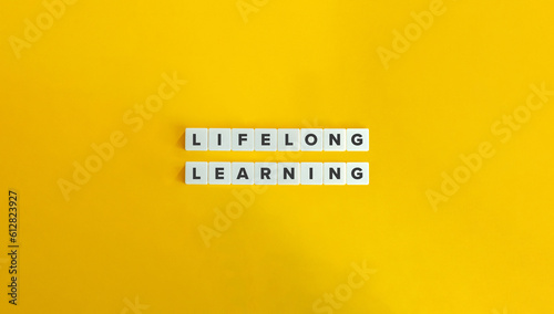 Lifelong Learning Term on Letter Tiles on Yellow Background. Minimal Aesthetic. photo