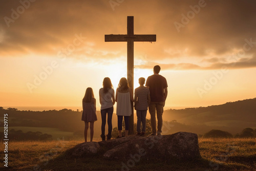 Billede på lærred Family standing next to a cross at sunset