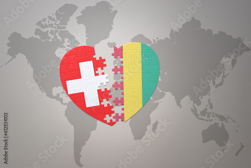 puzzle heart with the national flag of guinea and switzerland on a world map background.Concept.