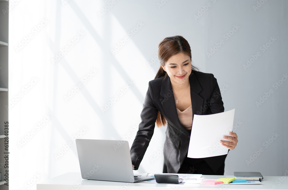 Young beautiful businesswoman working in the office room, using laptop computer on the office desk. Young beautiful businesswoman working in the office room, using laptop computer on the office desk.