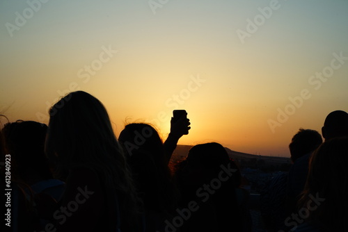 People silouettes shooting photos at the sunset in a summer day