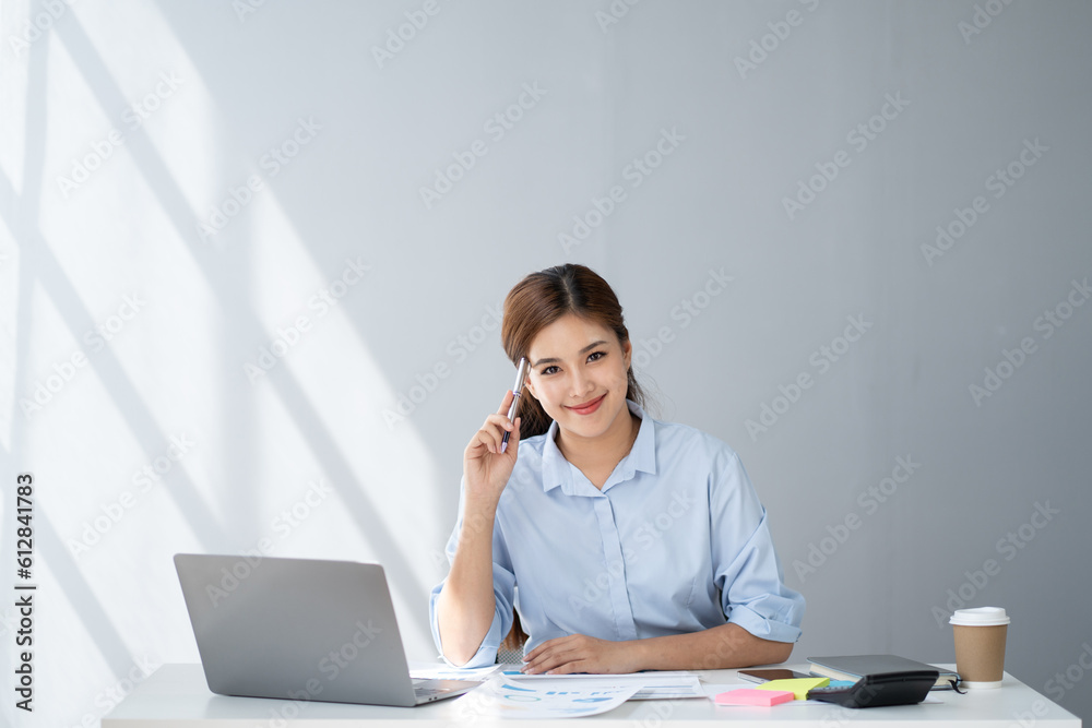 Charming Asian businesswoman focusing on her work, using her smartphone to contact with her clients. Charming Asian businesswoman focusing on her work, using her smartphone to contact with her clients.